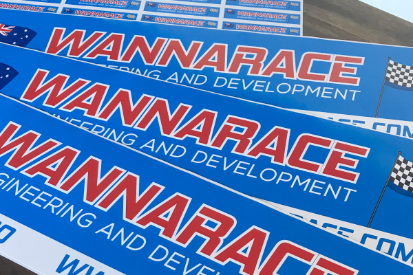 Race team logo bumper stickers laid out on table