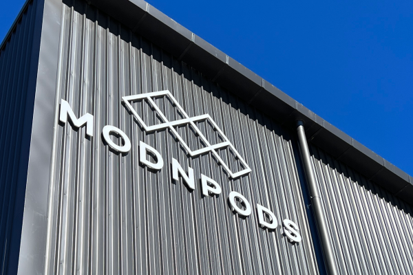 Grey colourbond factory with white raised lettering signage