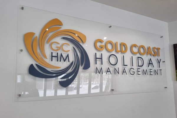 Clear acrylic wall sign with yellow and blue cut out vinyl logo applied to face