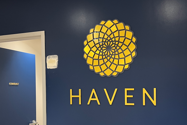 Gold acrylic cutout signage on blue reception wall