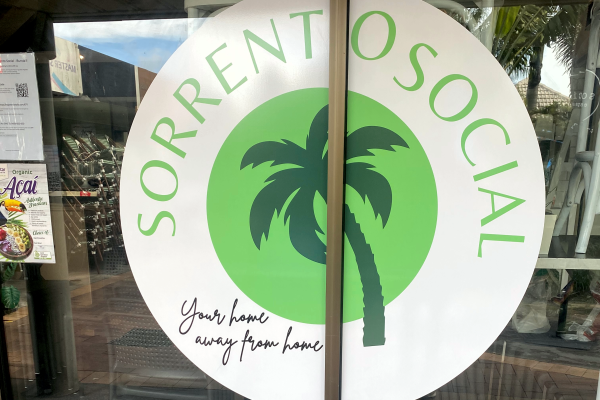 Cafe logo signage on external glass windows, split down centre of door frames