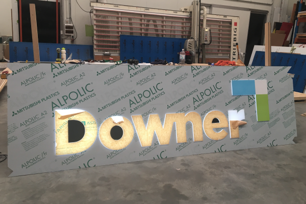 Push through lightbox in production showing the lit up word of 'Downer'