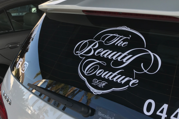 White cutout logo vinyl installed on back window of car