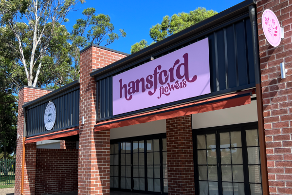 Front of building with pink and maroon coloured signage
