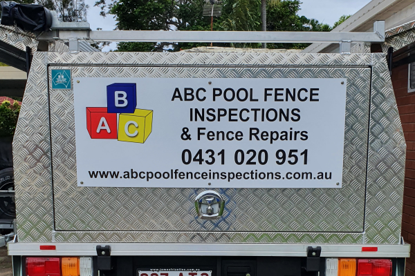 White sign with logo and text installed on back of ute canopy