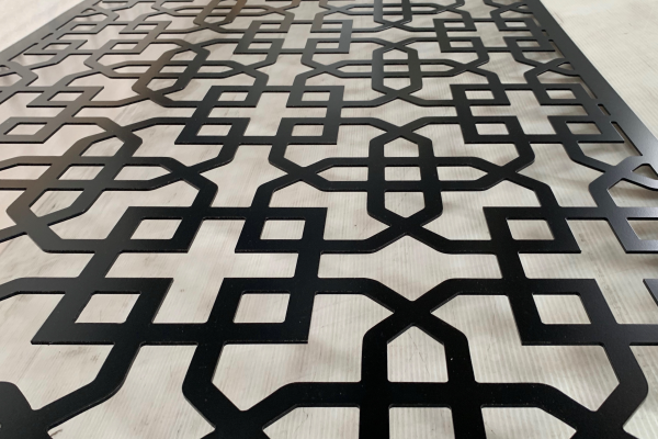 Black decorative screen laying down on white table