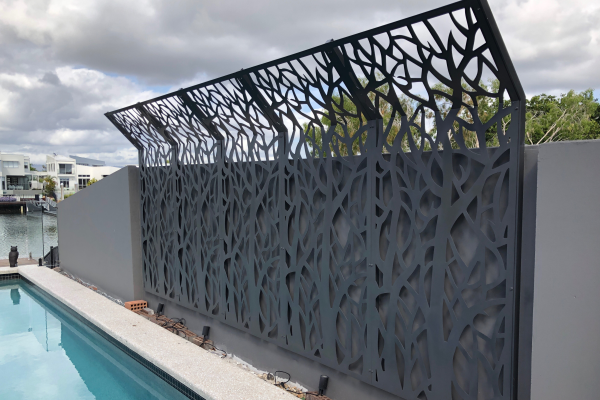 Grey semi folded decorative screens installed against fence near pool for privacy