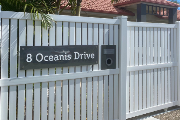 White Fence with Grey and white house sign