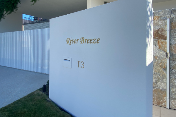 Gold letters installed onto a white external wall