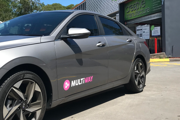 White and pink vehicle signage decal on grey car