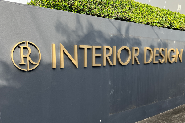 brass 3D letters installed onto a grey rendered wall