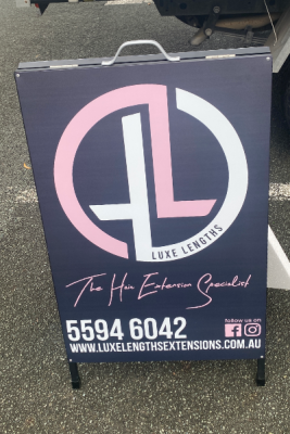 black, pink and white metal aframe sign