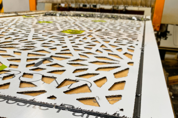 white ACM decorative screen being fabricated on CNC router