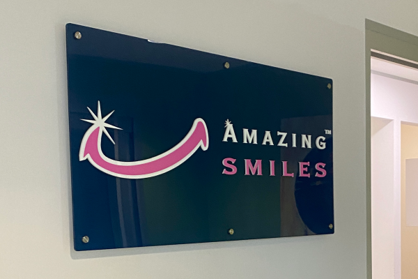 Blue, white and pink acrylic wall sign installed onto reception wall