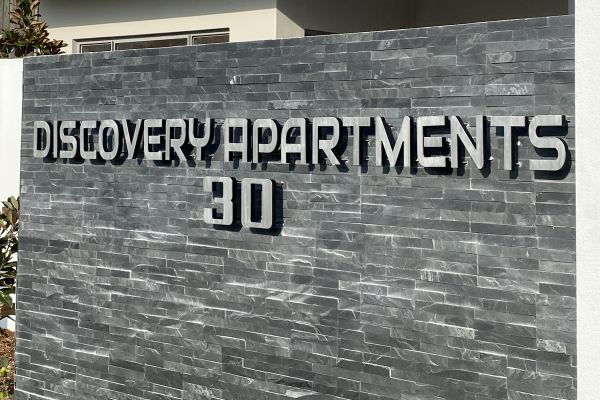 3D aluminium letters pin mounted signage onto a building rock fence