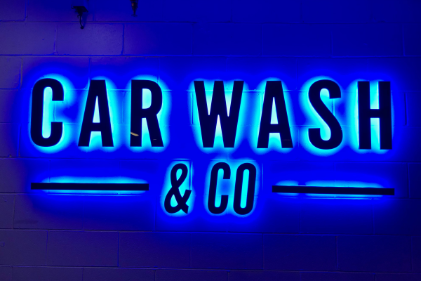 backlit illuminated letters with blue glow onto wall
