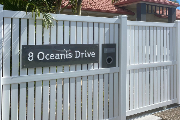 house / home acrylic sign installed onto a white fence